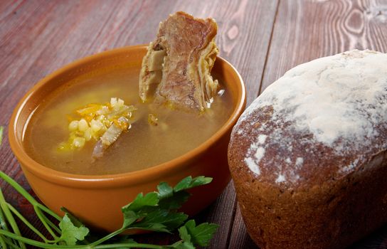 Pea soup with beef ribs  and farmhouse bread,edible greens .farmhouse kitchen