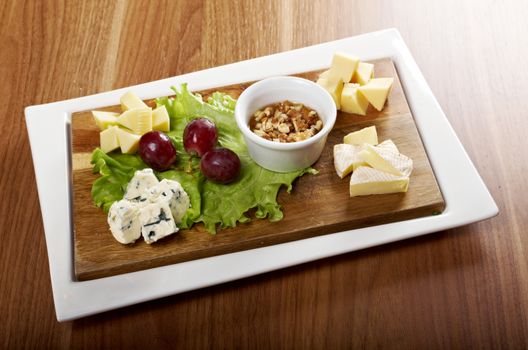 Various types of cheese on wooden platter