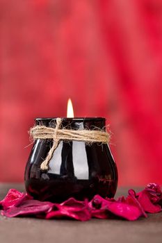 Black candle cup on red background, vertical shoot