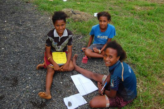 Three girls make schoolwork, Papua New Guinea