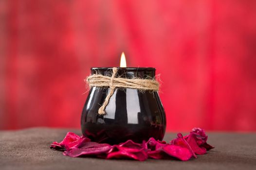 Black candle cup on red background, horizontal shoot