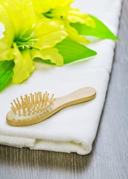 hairbrush and flower on towel