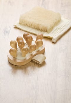 massager and bast on wooden background