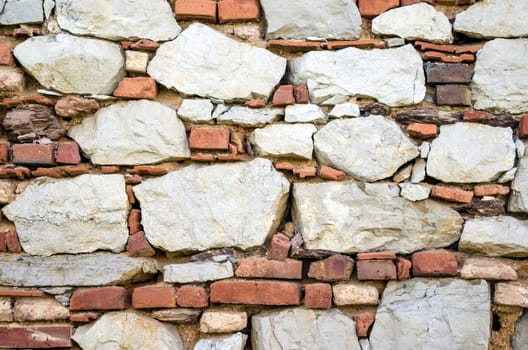 Old weathered stone and brick combined wall texture.