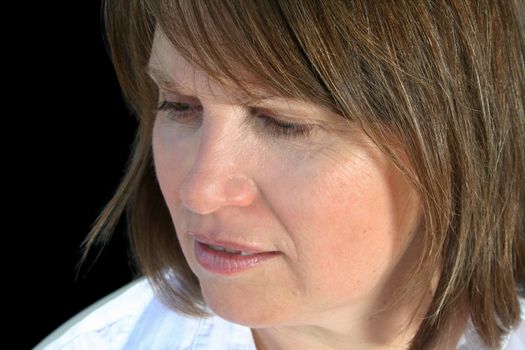 Close up of a middle aged female looking down.