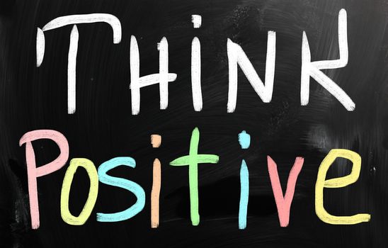 "Think positive" handwritten with white chalk on a blackboard