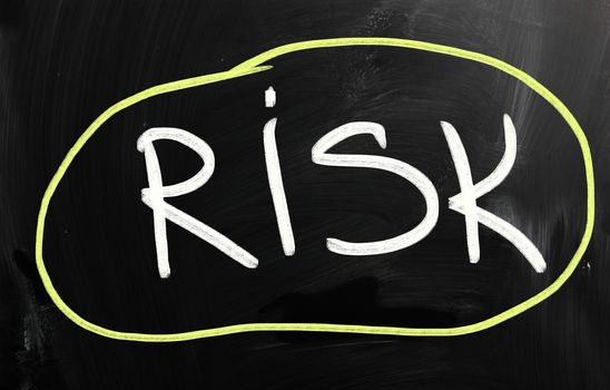 "Risk" handwritten with white chalk on a blackboard