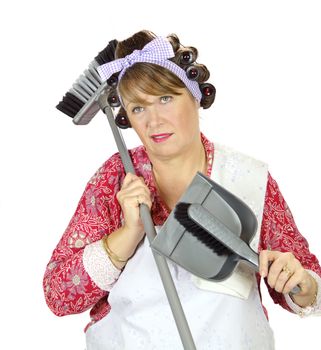 Middle aged frumpy house looks forlorn and exasperated holding a dust pan and broom.