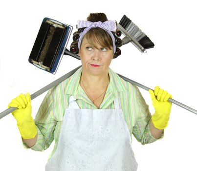 Bored frumpy housewife with carpet sweeper and broom over her shoulders.