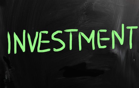 "Investment" handwritten with white chalk on a blackboard