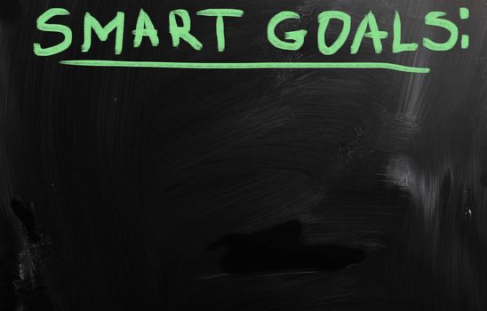 "Smart goals" handwritten with white chalk on a blackboard