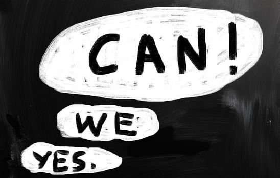 "Yes, we can!" handwritten with white chalk on a blackboard