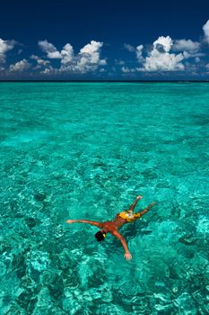 Man snorkeling in crystal clear turquoise water at tropical beach