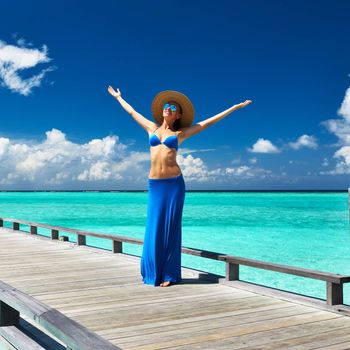 Woman on a tropical beach jetty at Maldives