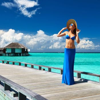 Woman on a tropical beach jetty at Maldives