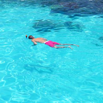 Man snorkeling in crystal clear turquoise water at tropical beach