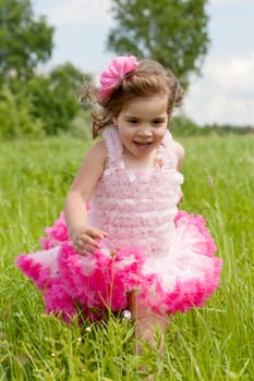 girl runs on a glade with a green grass