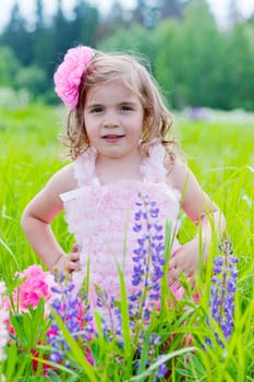 girl to stand among blossoming lupines