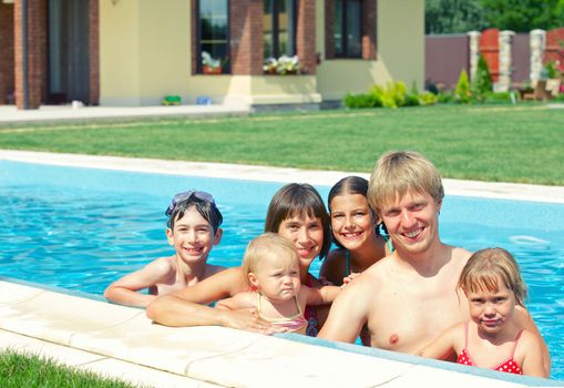 Summer vacation. Happy family with four kids in swimming pool outdoors