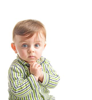 Lovely baby looking to the camera wearing his pajama holding his hands together