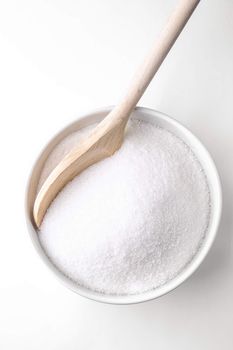 Wooden spoon and a bowl fill with sugar