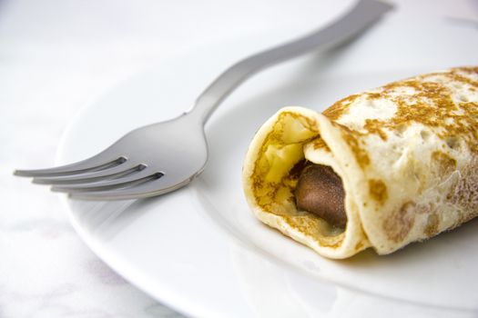 Chocolate crepe and a fork on a dish