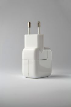 Apple charger on a grey plain background