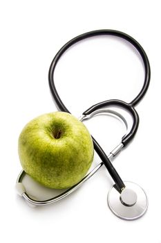 Green apple and a stethoscope on white background