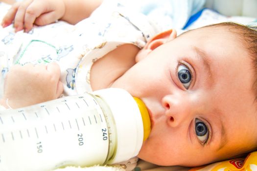 Lovely baby feeding on milk bottle