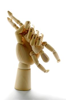 Wooden hand grabbing a much smaller wooden manikin