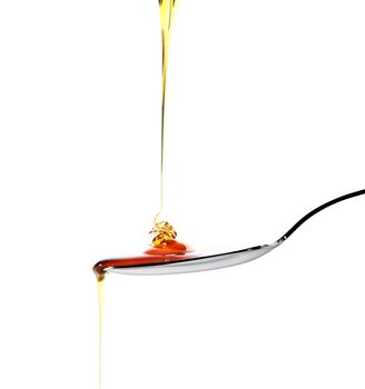 Dropping honey on a spoon isolated