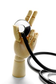 Stethoscope and wooden hand on white