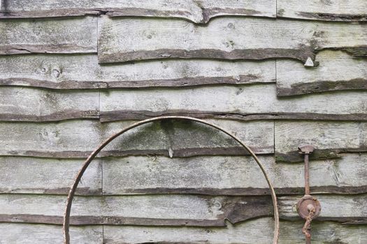 Wood slats with antique farm equipment.