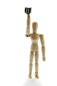 Wooden manikin with raising arm holding a dice