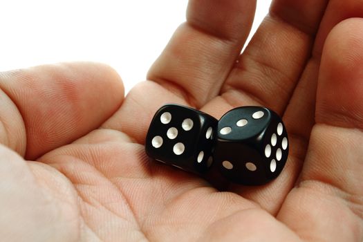 A hand holding two dices