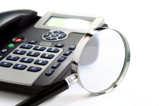 Black and silver telephone and magnification glass