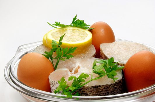 Lemon slices, eggs, hake and parsley