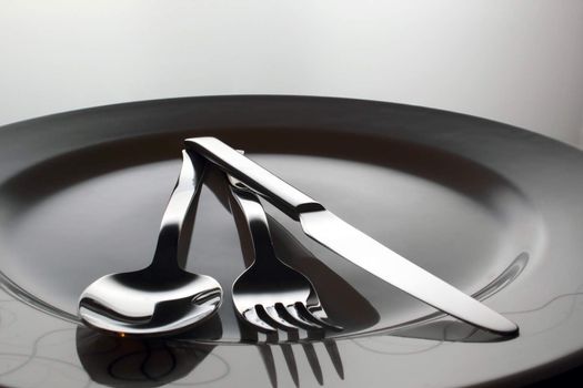 Silver Fork, knife and spoon on a dish