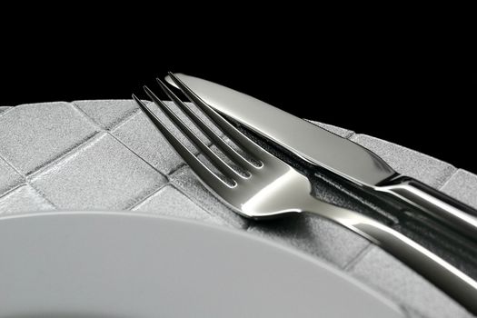 Cutlery and dish on black background