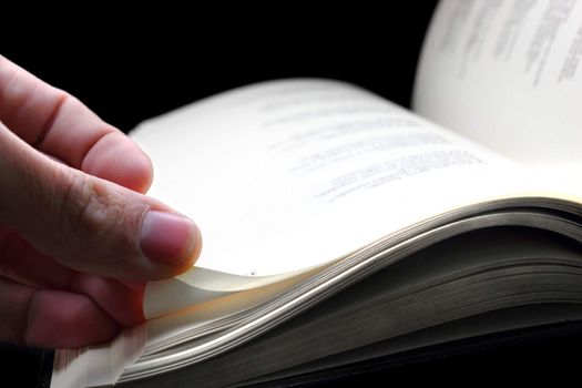 An hand turning a page of the book