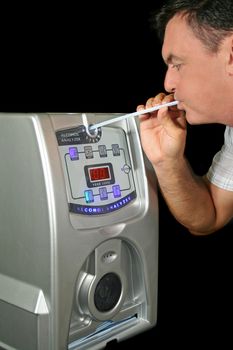 Man tests his alcohol level with a breath test machine.