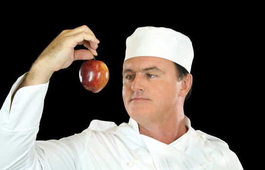 Chef holds up healthy apple and contemplates its use.