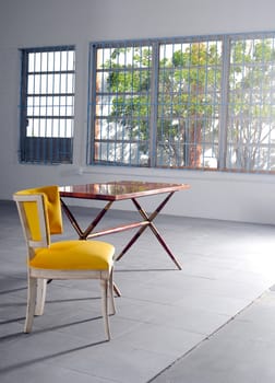 An empty yellow chair and table in minimalist loft
