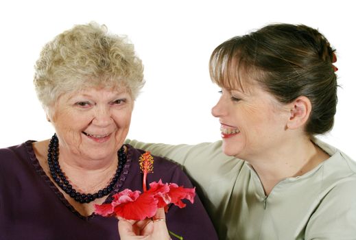 Daughter presenting mother with a hibiscus flower.