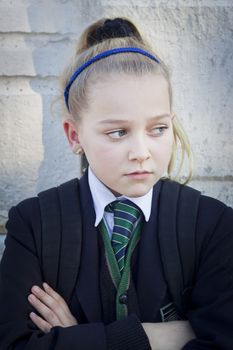 An upset teenager at school, looking away from camera. Candid shot, real people
