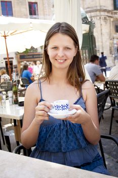 Teenager with espresso in Valletta, Malta, outside restaurant