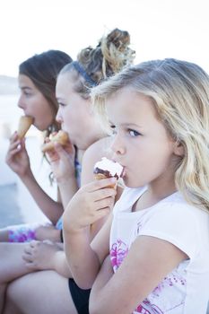 Three girls eating icecream. Focus on first girl
