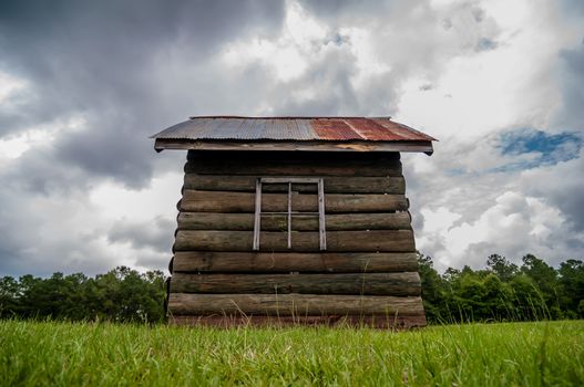 Old solid log cabin shelter near road and  the forest