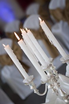 Close up of a silver candelabra with lit candles, shot in a tilted angle