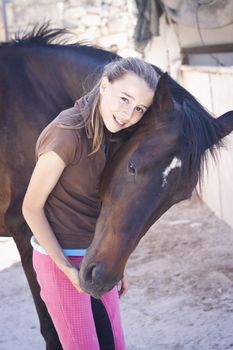 A teenage girl with her horse. Candid photo, happy feeling, best friends
